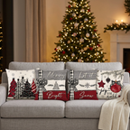 Quatro capas de almofada de Natal num sofá cinzento, junto à árvore iluminada